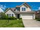 Charming two-story home with a well-maintained lawn and inviting curb appeal on a sunny day at 6472 Creekshore Ln, Indianapolis, IN 46268