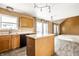 Bright kitchen with wood cabinets, a center island, modern light fixture, and an eat-in space at 6472 Creekshore Ln, Indianapolis, IN 46268