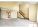 Spacious living room featuring neutral carpeting, vaulted ceiling, and staircase at 6472 Creekshore Ln, Indianapolis, IN 46268