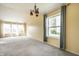 Bright living room boasts large windows, neutral carpet, and stylish chandelier at 6472 Creekshore Ln, Indianapolis, IN 46268
