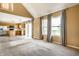 Bright living room showing open floor plan with kitchen and large windows with gray curtains at 6472 Creekshore Ln, Indianapolis, IN 46268