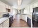 Functional kitchen design with white cabinets, black appliances, and hardwood flooring leading to the dining area at 6628 Dunsdin Dr, Plainfield, IN 46168