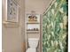 Bathroom features a toilet, shelving, and patterned shower curtain at 704 Baronne St, Lebanon, IN 46052