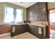 Efficient kitchen featuring ample dark cabinets, a stainless steel sink, and natural light from a window at 704 Baronne St, Lebanon, IN 46052