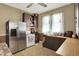 Well-lit kitchen showcasing a stainless-steel refrigerator, white appliances, and abundant cabinet space at 704 Baronne St, Lebanon, IN 46052