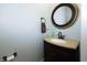 Powder room featuring a modern vanity with granite countertop, bronze fixtures, and a round mirror at 7926 White Pine Dr, Avon, IN 46123