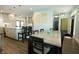 Dining area with a view of the kitchen, featuring an island, pendant lights and gray cabinets at 7926 White Pine Dr, Avon, IN 46123