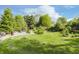 Lawn view of the backyard with mature trees and mulched landscaped areas at 807 Whitmore St, Anderson, IN 46012