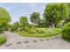 Backyard with garden featuring flowers, manicured lawn, trees and pebble pathway at 807 Whitmore St, Anderson, IN 46012