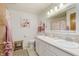 Bright bathroom featuring dual sinks, decorative mirror, and shower with curtain at 807 Whitmore St, Anderson, IN 46012