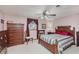 This cozy bedroom features wood furnishings, soft pink walls, and a ceiling fan at 807 Whitmore St, Anderson, IN 46012