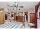 This cozy bedroom features wood furnishings, soft pink walls, and a ceiling fan at 807 Whitmore St, Anderson, IN 46012