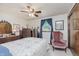 This bedroom features a vintage bed, antique dresser, ceiling fan, and an armchair beneath the window at 807 Whitmore St, Anderson, IN 46012