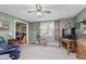 Bright living room with green walls and beige carpet with an exercise bike and other decor at 807 Whitmore St, Anderson, IN 46012
