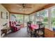The sunroom features a brick accent wall, wood plank ceiling, multiple windows and a ceiling fan at 807 Whitmore St, Anderson, IN 46012