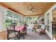 This airy sunroom features wood paneling, a ceiling fan, and plenty of natural light and views at 807 Whitmore St, Anderson, IN 46012