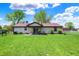 Beautiful backyard with a well-maintained lawn, patio area, mature trees, and a cozy seating area at 8141 Rob Ln, Indianapolis, IN 46237