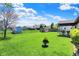 The backyard features a large, green lawn, a shed, a covered patio area, and mature trees at 8141 Rob Ln, Indianapolis, IN 46237