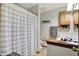 Bathroom features a shower and tub combination with a white curtain, a toilet, and a vanity with a wood-trimmed mirror at 8141 Rob Ln, Indianapolis, IN 46237