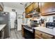 Galley kitchen featuring wood cabinets, stainless appliances, and adjacent laundry area at 8141 Rob Ln, Indianapolis, IN 46237