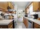 Galley kitchen features wood cabinets, stainless appliances, and adjacent dining area at 8141 Rob Ln, Indianapolis, IN 46237