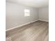 Neutral bedroom featuring durable modern flooring, baseboard trim, and a large window at 8145 Railroad Rd, Indianapolis, IN 46217