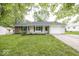 Charming one-story home with a well-manicured lawn and attached garage, complemented by a cozy front porch at 8145 Railroad Rd, Indianapolis, IN 46217