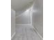 Unfinished attic space featuring gray carpeting, sloping walls and ceiling, and a small window at 820 Scotch Pine Dr, Greenwood, IN 46143