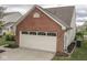 Attached two-car garage with brick and vinyl siding, complementing the home's exterior at 820 Scotch Pine Dr, Greenwood, IN 46143