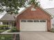 Charming single-story home featuring a red brick facade and a two-car garage with a well-manicured lawn at 820 Scotch Pine Dr, Greenwood, IN 46143