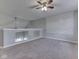Open-concept living area with neutral carpet, a ceiling fan, and half wall, offering ample space at 820 Scotch Pine Dr, Greenwood, IN 46143