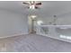 Open-concept living area with neutral carpet, a ceiling fan, and half wall, offering ample space at 820 Scotch Pine Dr, Greenwood, IN 46143