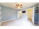 Bedroom features neutral carpet, modern ceiling fan, wall-mounted television and a closet with shelving at 8727 Redditch Dr, Avon, IN 46123