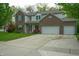 Charming two-story home featuring a well-manicured lawn, brick accents, and an attached two-car garage at 8727 Redditch Dr, Avon, IN 46123