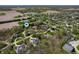 Expansive aerial view of residences with lush landscaping and winding driveways nestled among mature trees at 923 Woodcrest Way, Anderson, IN 46012