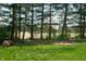 Well-manicured backyard featuring a fire pit, wood pile, trees and lush green lawn at 923 Woodcrest Way, Anderson, IN 46012