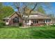 Expansive backyard with well-maintained lawn, mature trees, and a charming deck with furniture at 923 Woodcrest Way, Anderson, IN 46012