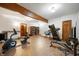 Spacious basement gym with exercise equipment, wood beam, built-in bookshelves, and neutral colors at 923 Woodcrest Way, Anderson, IN 46012