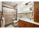 Bathroom featuring glass vessel sink, updated fixtures, tiled shower, and a decorative mirror at 923 Woodcrest Way, Anderson, IN 46012