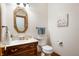 Traditional powder room featuring an oval mirror, marble countertop, and decorative fixtures at 923 Woodcrest Way, Anderson, IN 46012