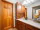 Bathroom featuring a solid surface vanity with wood cabinets and a large framed mirror at 923 Woodcrest Way, Anderson, IN 46012