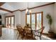 Light-filled dining room showcases wood table and chairs, large windows, and traditional chandelier at 923 Woodcrest Way, Anderson, IN 46012