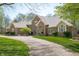 Charming brick home featuring a well-manicured lawn and a long driveway leading to the residence at 923 Woodcrest Way, Anderson, IN 46012