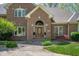 Elegant front entrance with brick facade, arched doorway, and well-maintained landscaping at 923 Woodcrest Way, Anderson, IN 46012
