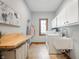 Bright laundry room with white cabinets, folding counter, washer, dryer, sink and light blue walls at 923 Woodcrest Way, Anderson, IN 46012