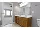 Bathroom featuring double sink vanity, decorative mirror, and lighting at 9417 Glencroft Way, Indianapolis, IN 46250