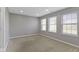 Empty bedroom with neutral carpet and paint, three windows, and a closet at 9417 Glencroft Way, Indianapolis, IN 46250