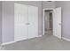 A carpeted bedroom with white closet doors and a doorway to the next room at 9417 Glencroft Way, Indianapolis, IN 46250