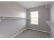 Walk-in closet featuring built-in shelving units and a window for natural light at 9417 Glencroft Way, Indianapolis, IN 46250