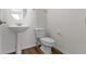 Neat half bathroom featuring a pedestal sink, wood-style flooring, and modern fixtures at 9417 Glencroft Way, Indianapolis, IN 46250